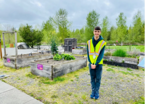 Student standing in front of planters smiling.