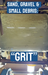 Clear pipe section showing sand, gravel, and small debris, known as grit, moving through wastewater during high flows.