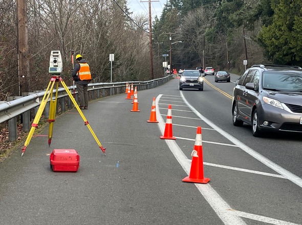 Survey work taking place on the shoulder of the roadway