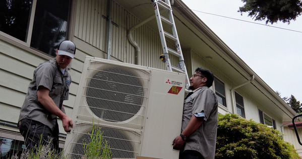 Two men installing a heating system.