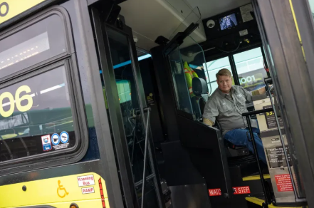 Member of the Vehicle Maintenance staff demonstrating the new Operator Safety Partition 
