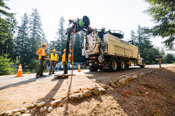 Tres trabajadores están alrededor de un camión de limpieza de alcantarillas del condado de King en Black Diamond.