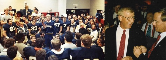 A coach in a blue jacket addresses a football team in a locker room. To the right, two men in suits, Lou Holtz and Pete von Reichbauer, shake hands.