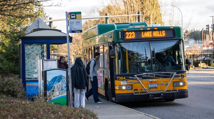 Picture of a bus stop for Route 223 and 245 and riders boarding a Route 223