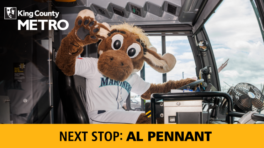 Image of the Mariners Moose sitting in the driver seat of the bus with the text "Next Stop: AL Pennant"