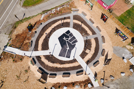 A circular courtyard with a large Black Power clenched fist in the middle. Raised garden beds circle the outside perimeter.