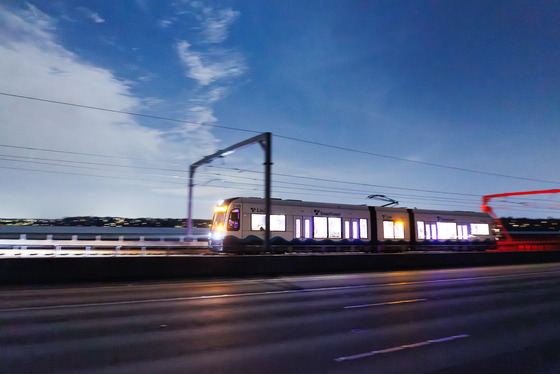 A light rail train crossing the I-90 bridge at dusk