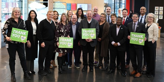 Councilmember Fain with the entire Sound Transit Board in the lobby of the Tacoma Art Museum holding signs saying Thank You