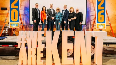 CM. Fain on a stage with six other mayors in front of a sign saying #we are kent