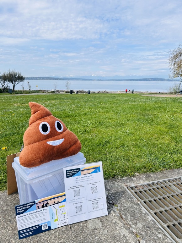 A file bin at Lowman Beach Park with project information in the front and a poop‑emoji plush toy on top. The staff used these to do outreach.