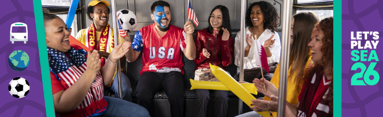 People celebrating in a bus. Some are holding flags and noisemakers with the "Let's Play SEA 26" logo in preparation for FIFA World Cup.