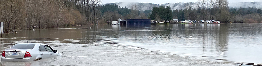 Homes and a vehicle in flood water