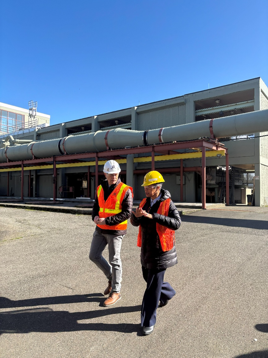 Photo of Councilmember Lewis walking and talking with a man at a Wastewater Treatment Plant