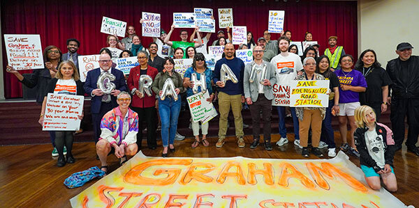 Large group holding Save Graham Street Station signs.