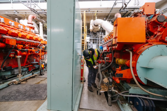 Crew member working around the engines of the Raw Sewage Pump Building. 