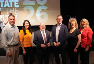 Steffanie standing alongside five individuals in a dark theater