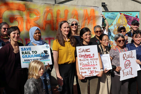 photo of several people holding signs supporting the building of the Graham Street station.