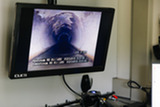 image of inside a sewer pipe as shown on a closed-circuit television screen