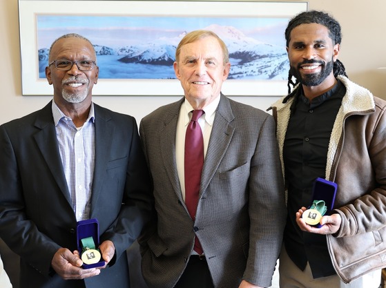 Councilmember Pete von Reichbauer with Ken and Jesse Johnson, each holding an MLK medal.