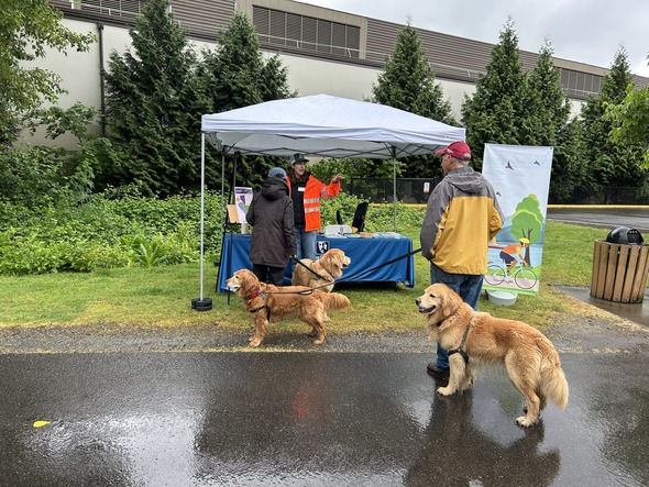 A photo of a King County WTD member talking with two community members on a rainy day on the East Lake Sammamish Trail.