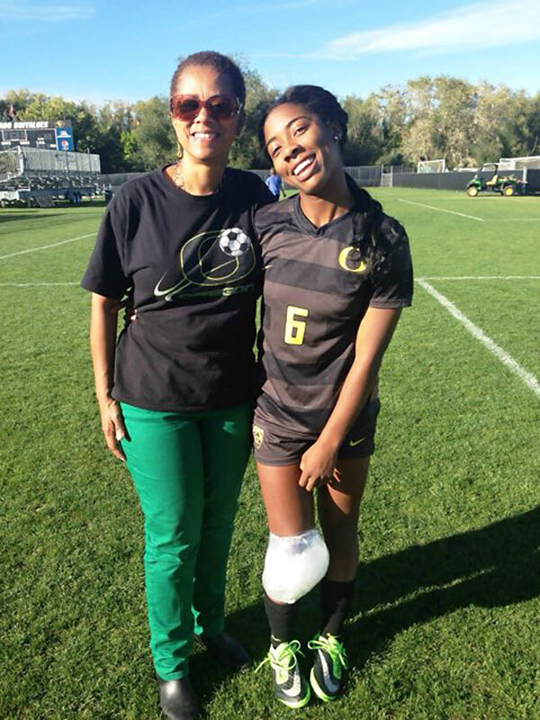 photo of two women standing together on a soccer pitch