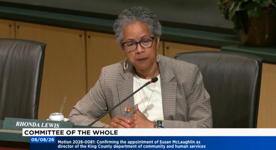 screenshot of Rhonda Lewis speaking from the dais