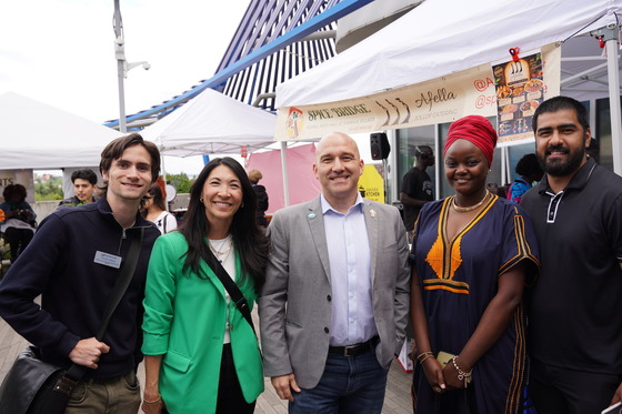 five individuals standing in front of a food vendor at SeaTac's Farmers Market