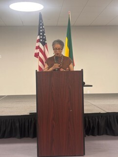 CM Lewis speaking at a podium 