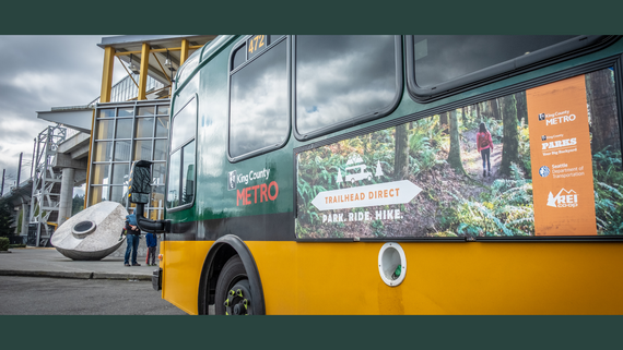 A dark green and yellow bus with King County Metro painted on the side.