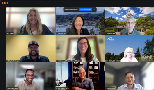 Zoom meeting with nine participants smiling for a screenshot