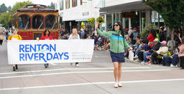 CM. Fain walking in front of a sign stating Renton river Days
