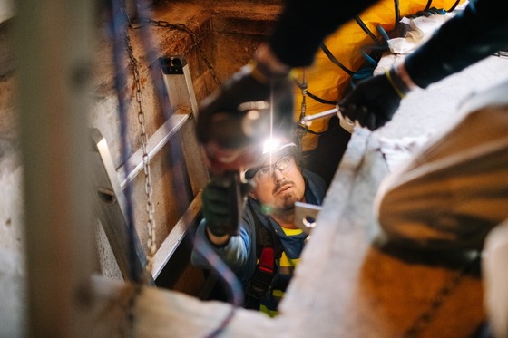 Worker shines flashlight during installation project.