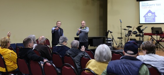 Councilmember von Reichbauer & Deputy Assessor Dams in an indoor meeting room, addressing an audience about the Senior Property Tax relief program.