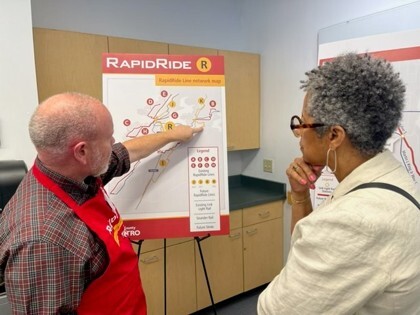 Jerry Roberson from Metro shows CM Lewis plans for the RapidRide R line at a recent community meeting.