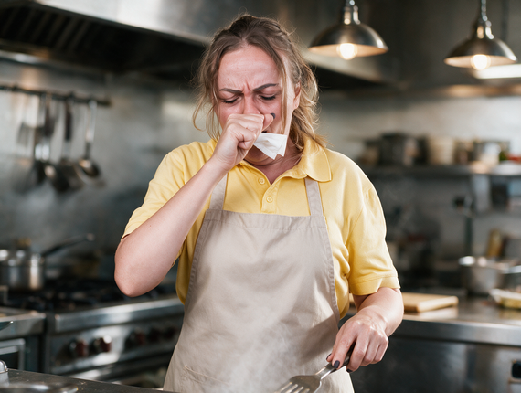 woman cooking and sneezing