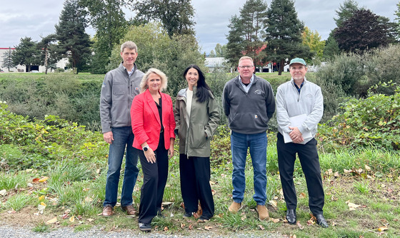CM. Fain standing with Mayor Dana Ralph and three other individuals in front of a river on a cloudy day