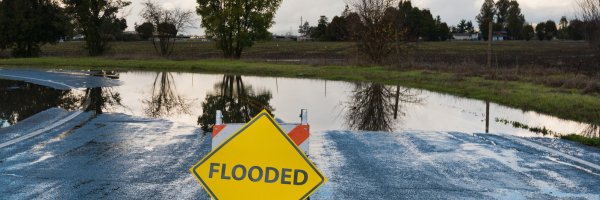 Flooded street sign in front of flooded street