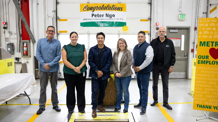 a banner that says "Congratulations Peter Ngo" and six people standing in a line 