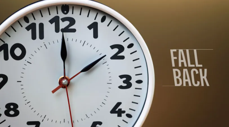 Image of a wall clock with brown background and text that says "Fall back"