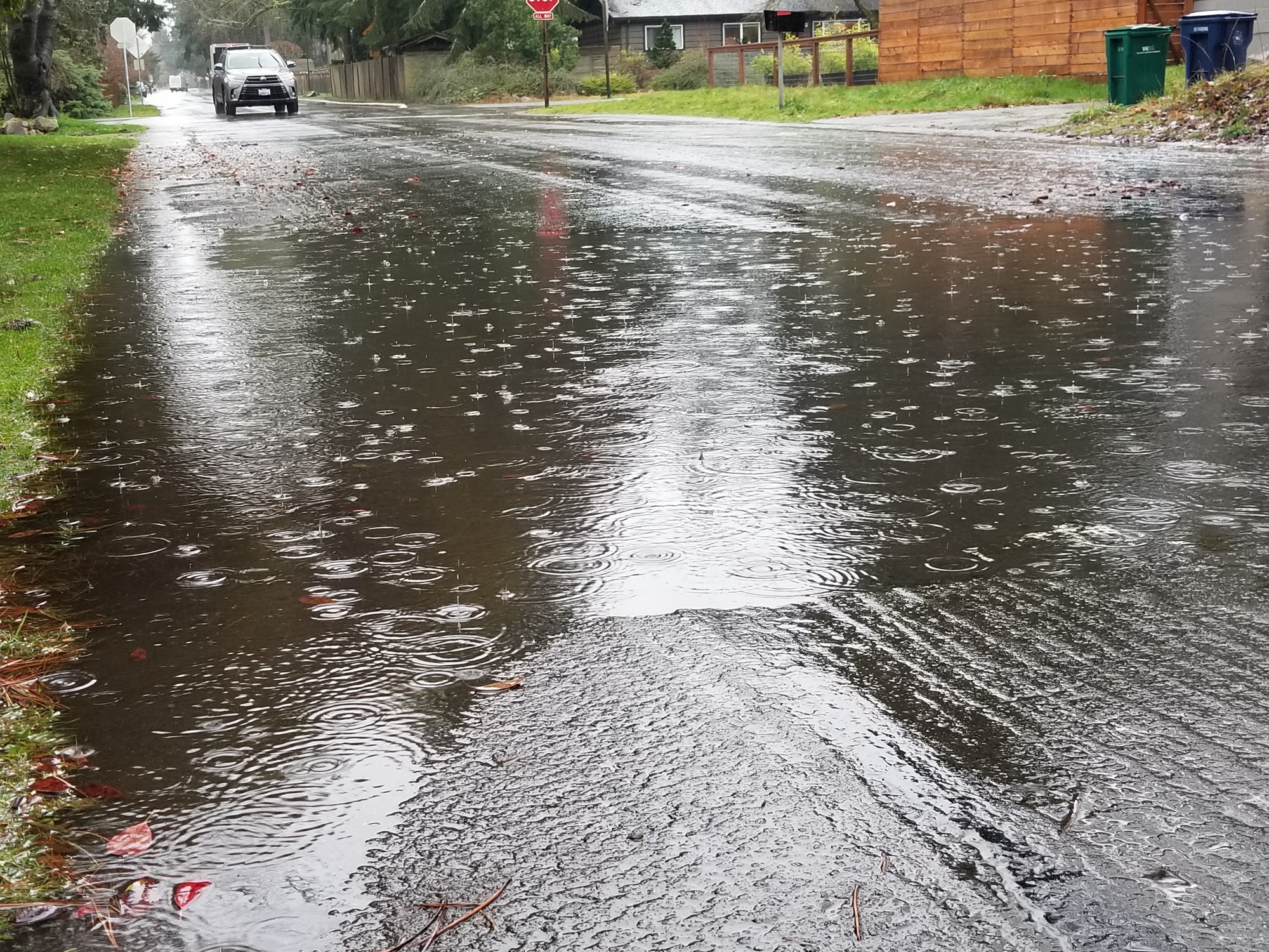 Flooding over a road with a car in the background