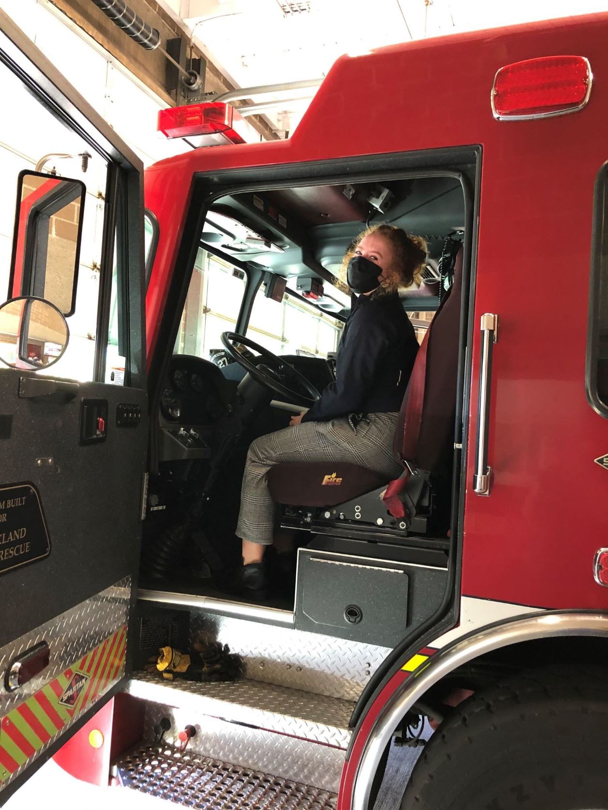 Amy Haining sitting in a fire truck and looking at the camera