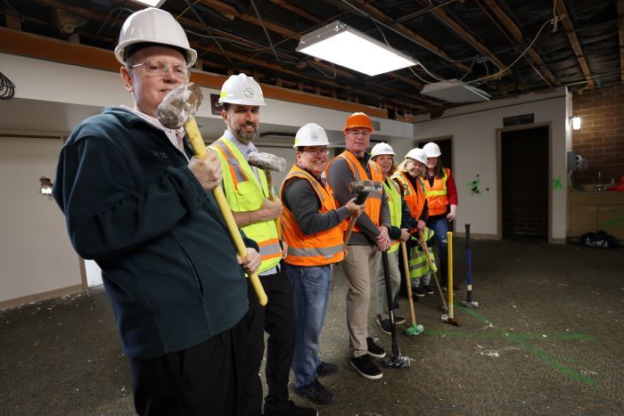 Kirkland Councilmembers posing with hammers at a ceremonial wall breaking