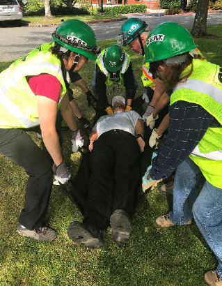 CERT trainees lifting a person on a medical apparatus