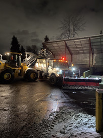 loader refills materials into snow plow truck