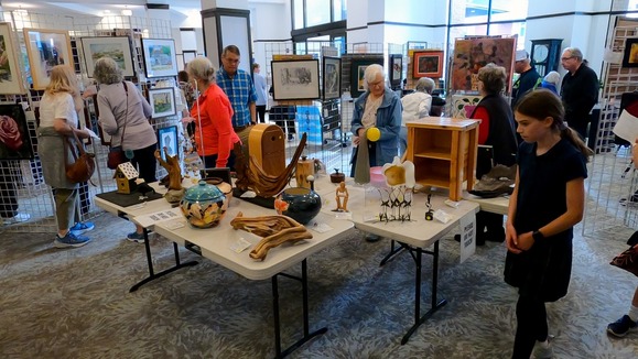 Image shows Senior Art show attendees looking at art
