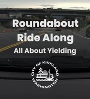 Image shows driver's view with a City of Kirkland logo and texting reading, "Roundabout Ride Along: All About Yielding"