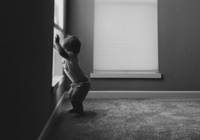 Toddler standing by a window