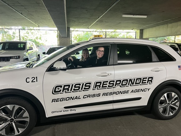 Photo of two people in a car that says CRISIS RESPONDER