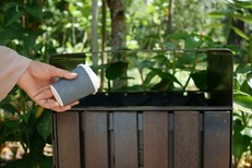 Image shows a compostable cup in front of a bin
