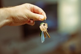 Image shows a hand holding keys